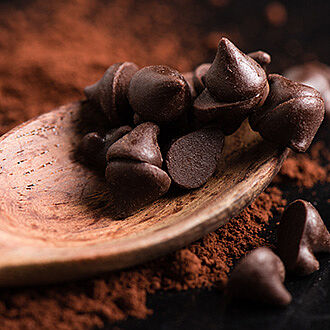 Cocoa powder and spoon with chocolate drops